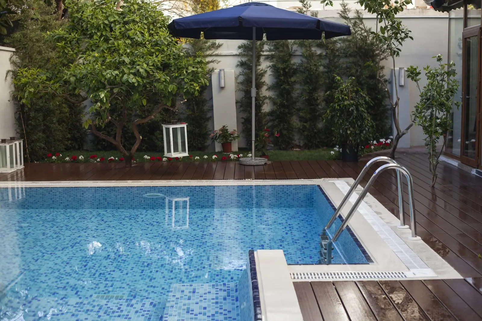 Tiled garden swimming pool with steps and a decked surround