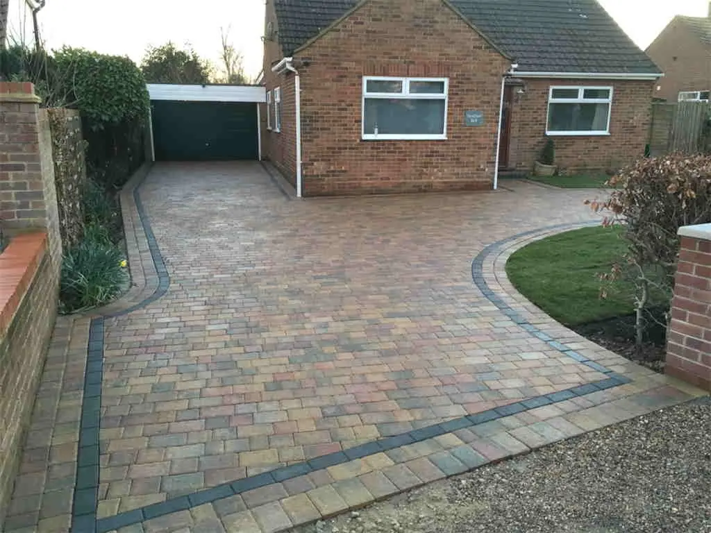Brindle block paved driveway with a border leading to a garage