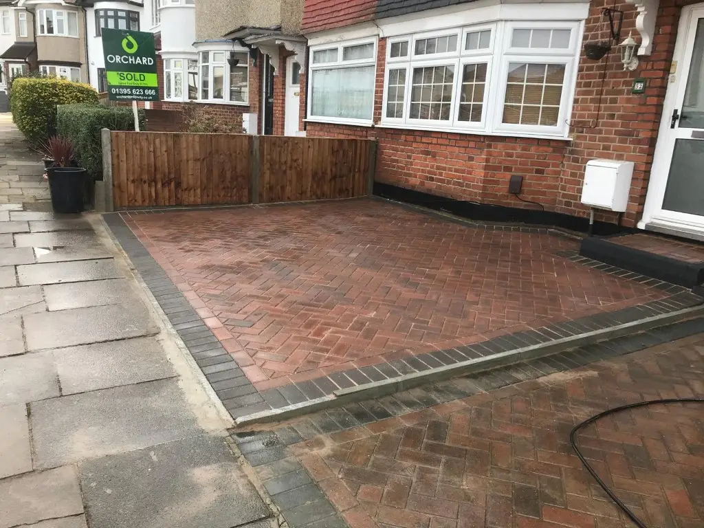 Red block paved front garden with new fencing
