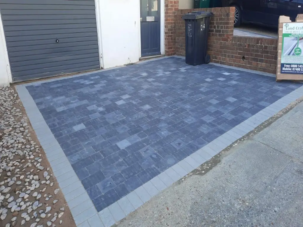 Charcoal block paving with a silver border in front of a garage