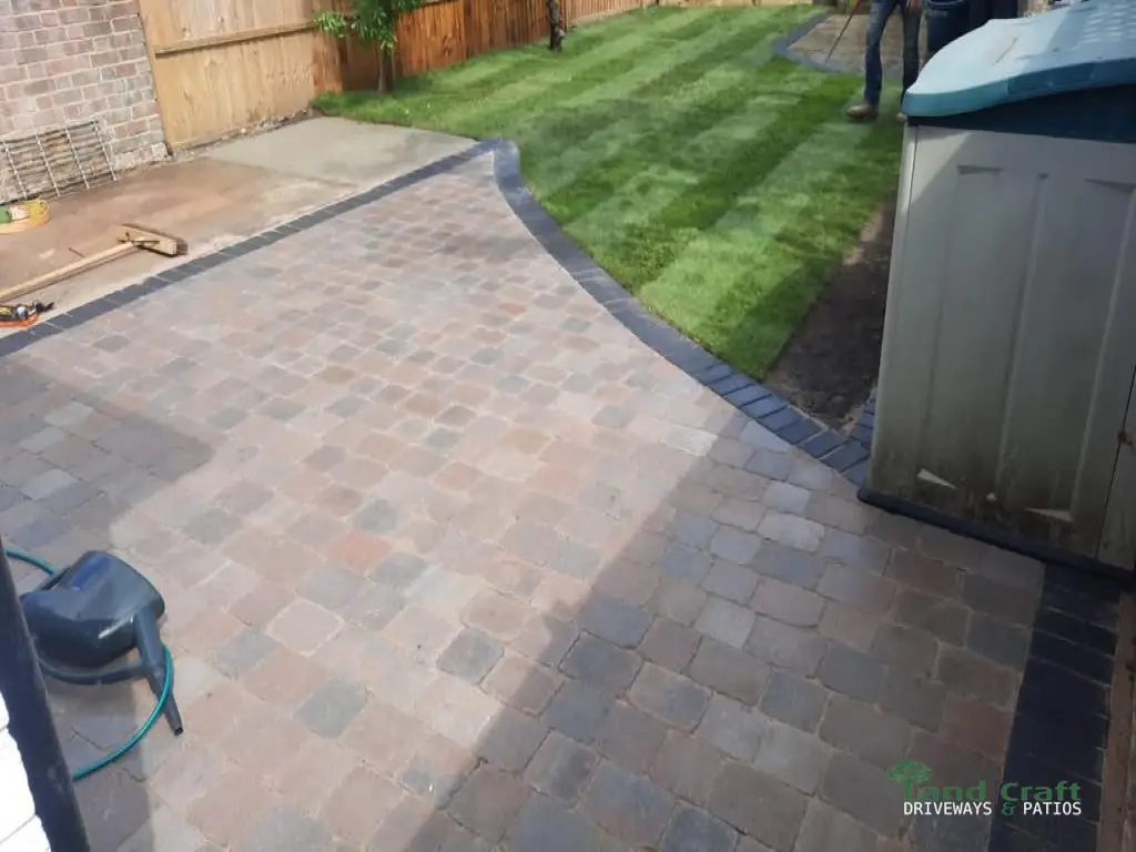 Brindle block paving with a charcoal border beside a lawn