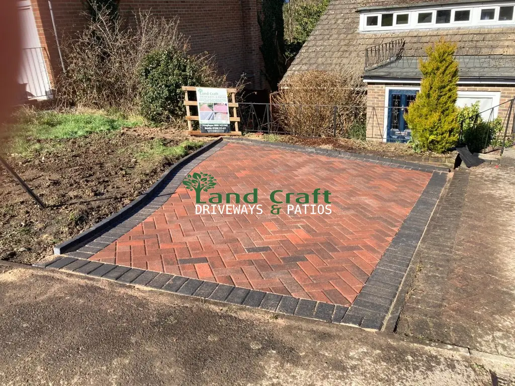 Red block paving with a charcoal border in front of a bungalow