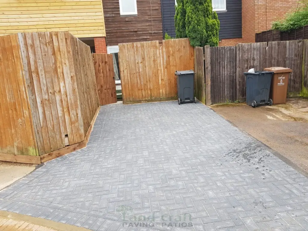 Grey block paving beside new timber fencing