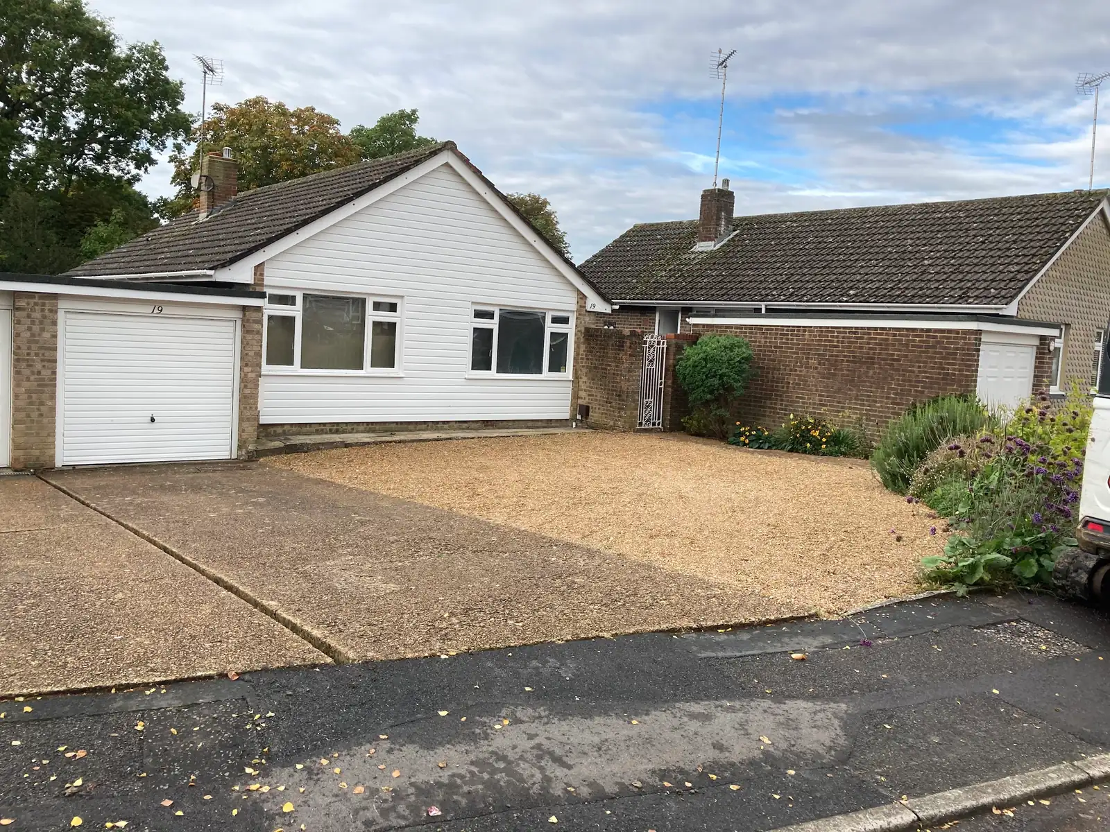 Gravel driveway with a tarmac entrance outside a bungalow