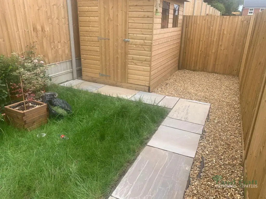 Gravel, turf and paving beside a garden shed