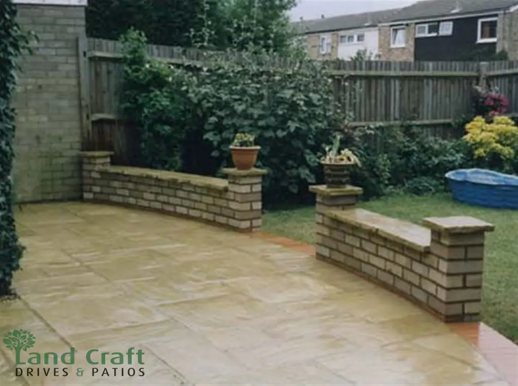 New brick garden walls and planters around a sandstone patio