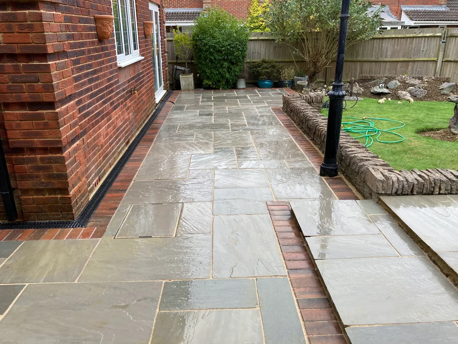 Grey stone path and patio with a red brick border