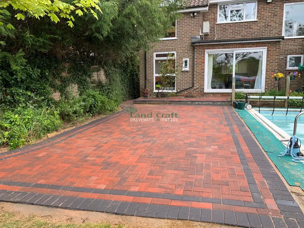 Red block paving around a garden swimming pool