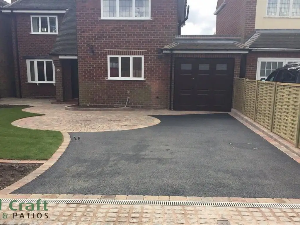 Tarmac driveway with a block paved border and curved lawn
