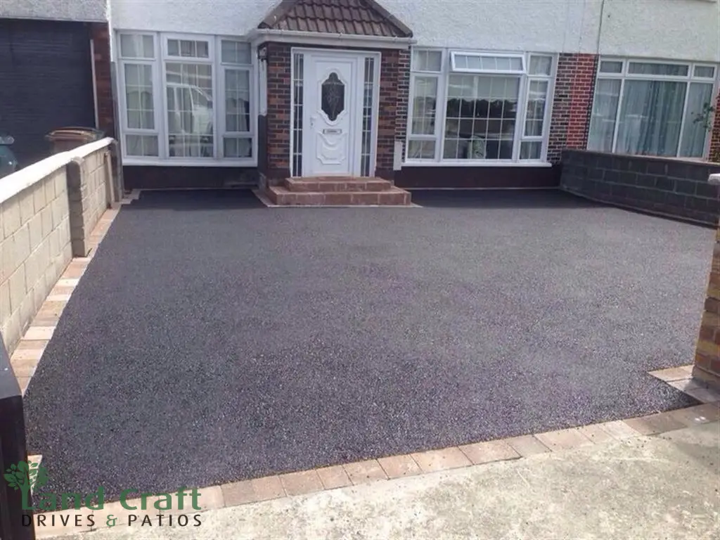 Dark tarmac driveway with a red block border