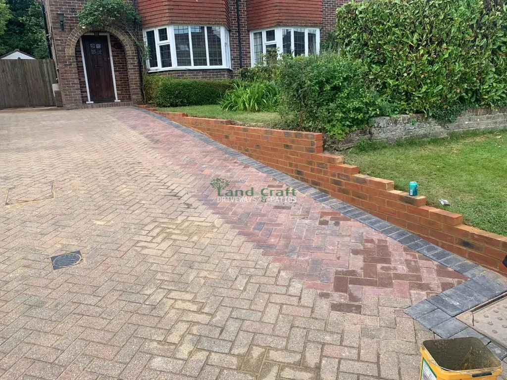 Herringbone block paving beside a new brick retaining wall